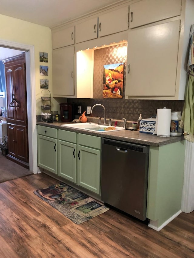 kitchen featuring green cabinetry, dishwasher, dark countertops, dark wood-style flooring, and a sink