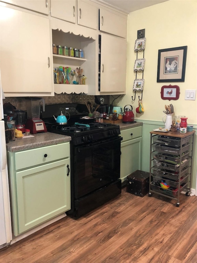 kitchen with dark wood-style flooring, open shelves, dark countertops, green cabinets, and gas stove