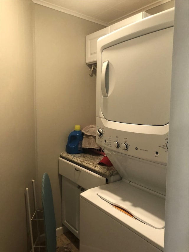 laundry room featuring stacked washer and dryer, laundry area, and crown molding