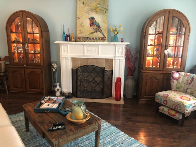 living area featuring a tiled fireplace and wood finished floors