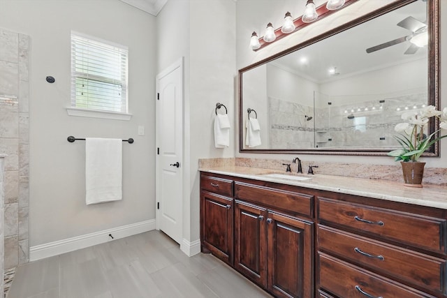 bathroom featuring baseboards, ornamental molding, walk in shower, and vanity