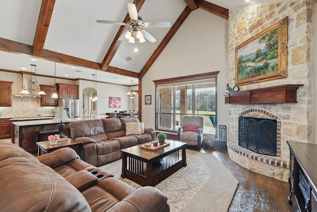 living room featuring dark wood-style flooring, beam ceiling, a fireplace, visible vents, and high vaulted ceiling