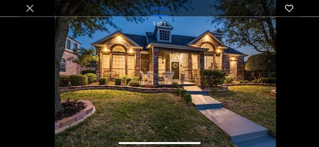 view of front facade featuring stone siding and a front lawn