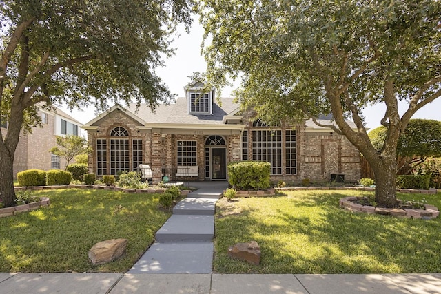 view of front of house with brick siding and a front yard