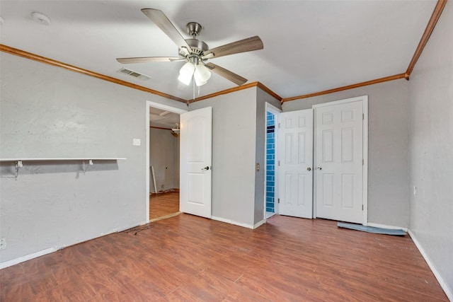 interior space with wood finished floors, visible vents, and crown molding