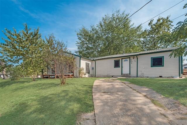 view of front of house with metal roof, a front lawn, and a standing seam roof