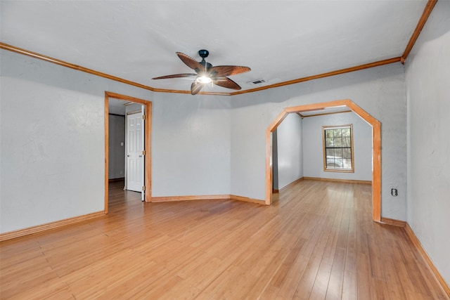 empty room with visible vents, baseboards, a ceiling fan, light wood-style flooring, and ornamental molding