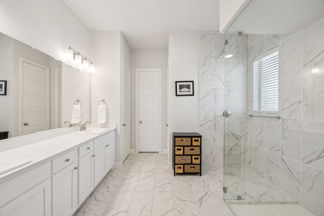 bathroom with marble finish floor, a sink, a marble finish shower, and double vanity