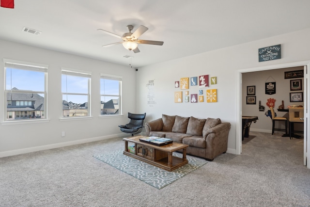 living area featuring ceiling fan, carpet flooring, visible vents, and baseboards