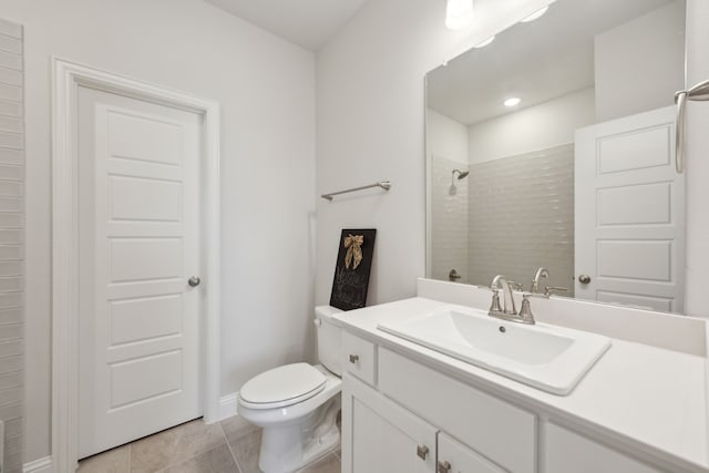 full bath featuring toilet, tile patterned flooring, tiled shower, and vanity