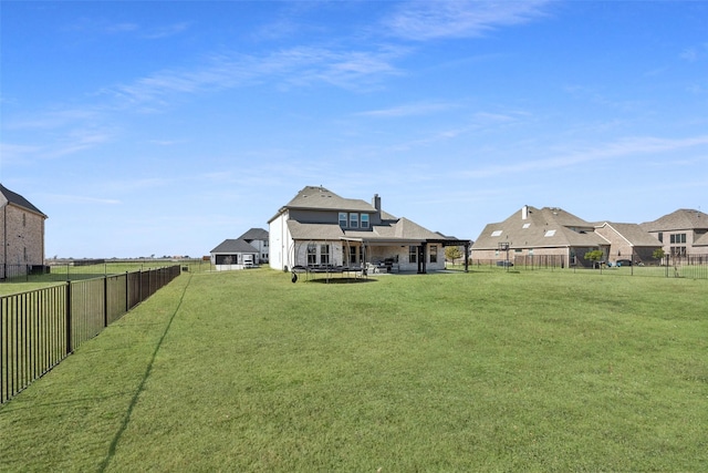 view of yard with a trampoline and a fenced backyard