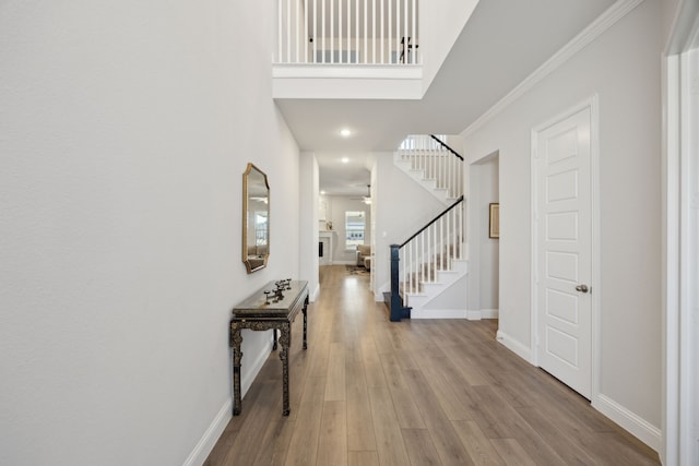 entrance foyer featuring ceiling fan, wood finished floors, baseboards, stairs, and ornamental molding