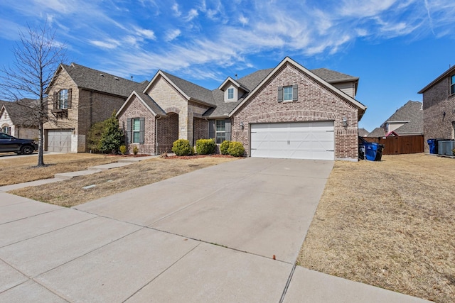 view of front facade with brick siding, concrete driveway, central AC unit, fence, and a garage