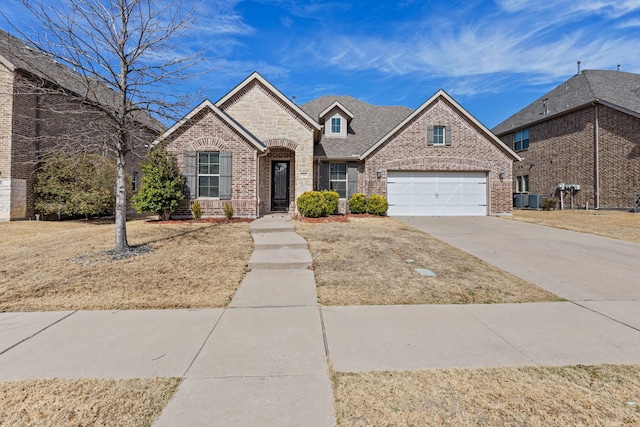 view of front of property with a garage, brick siding, driveway, stone siding, and roof with shingles