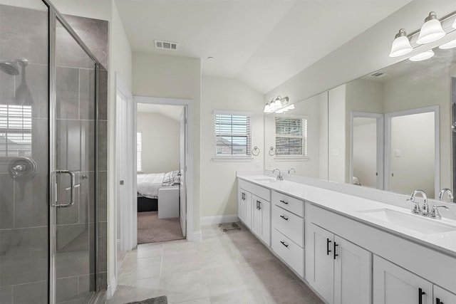 ensuite bathroom with double vanity, lofted ceiling, visible vents, a sink, and a shower stall