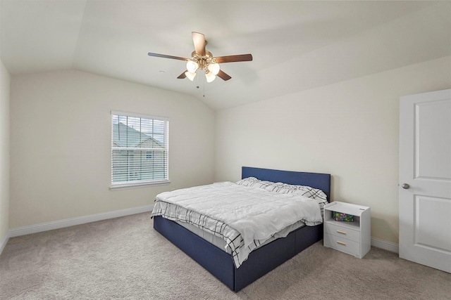 bedroom featuring carpet flooring, vaulted ceiling, baseboards, and ceiling fan