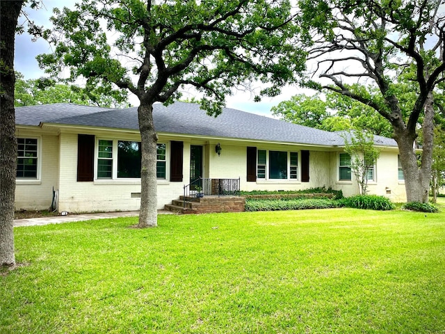 1265 S Main St, Jacksboro, TX 76458 - ranch-style house with brick siding, a front yard, and a shingled roof