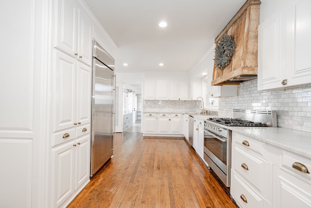 1265 S Main St, Jacksboro, TX 76458 - kitchen featuring appliances with stainless steel finishes, light countertops, decorative backsplash, white cabinetry, and recessed lighting