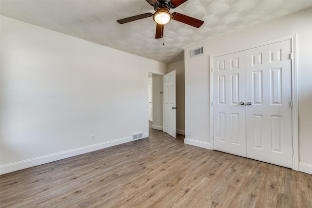 unfurnished bedroom with light wood-style flooring, visible vents, and baseboards