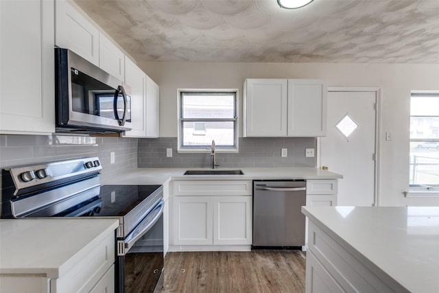 kitchen featuring light wood finished floors, appliances with stainless steel finishes, light countertops, and a sink