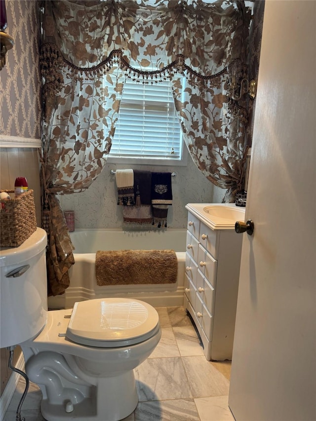 bathroom with toilet, wallpapered walls, a tub to relax in, and vanity