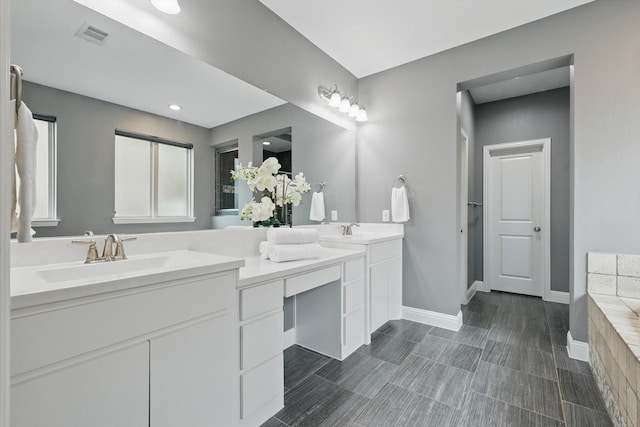 full bathroom featuring double vanity, visible vents, baseboards, and a sink