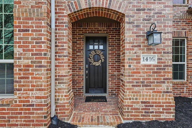 doorway to property featuring brick siding