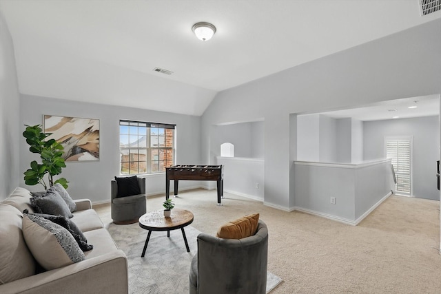 living area with lofted ceiling, plenty of natural light, visible vents, and light carpet