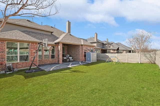 rear view of house with brick siding, a fenced backyard, a yard, and a patio