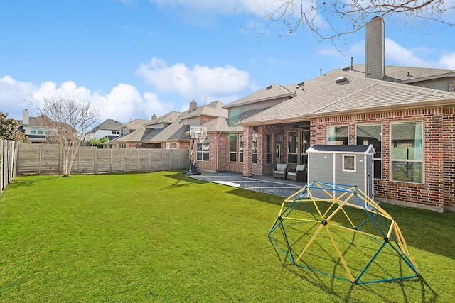 rear view of property featuring brick siding, a fenced backyard, and a patio area