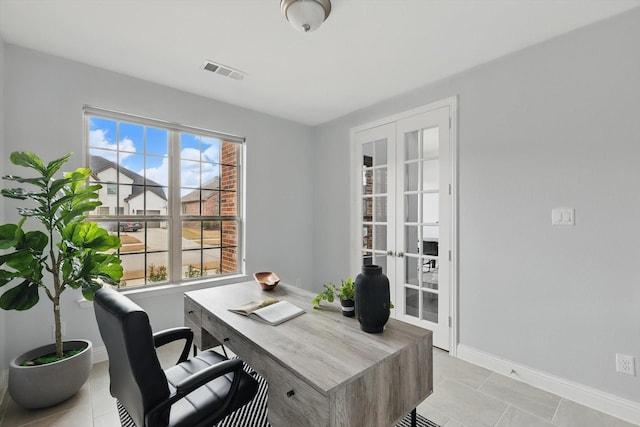 office space with light tile patterned flooring, visible vents, french doors, and baseboards