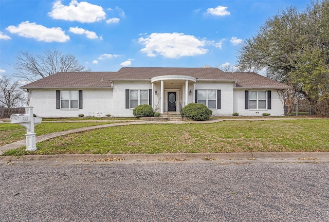 single story home with brick siding, roof with shingles, and a front lawn