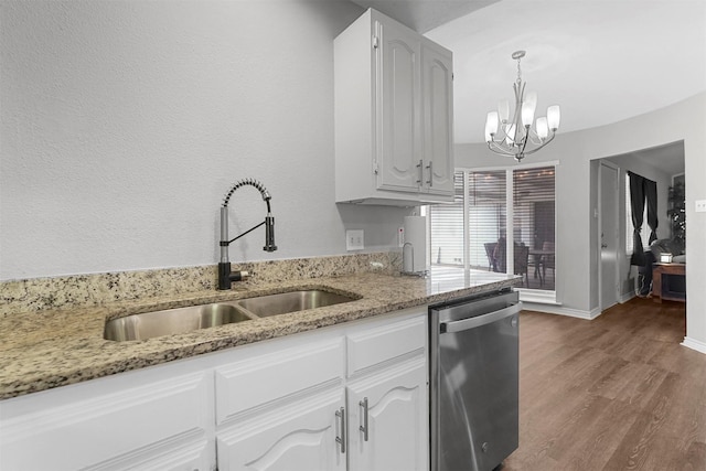 kitchen with light stone counters, wood finished floors, a sink, stainless steel dishwasher, and a notable chandelier