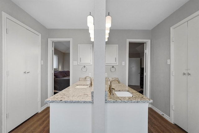 kitchen with dark wood-style flooring, white cabinets, and a sink