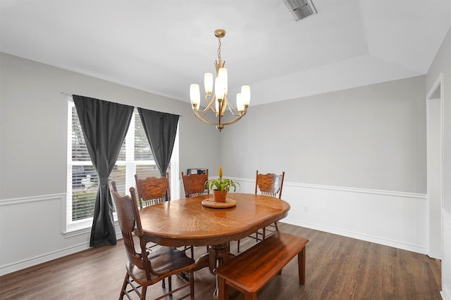 dining space with a notable chandelier, wood finished floors, visible vents, and baseboards