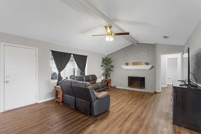 living room with a ceiling fan, visible vents, vaulted ceiling with beams, a fireplace, and light wood-style floors