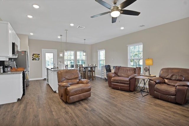 living room with dark wood-type flooring, recessed lighting, visible vents, and baseboards