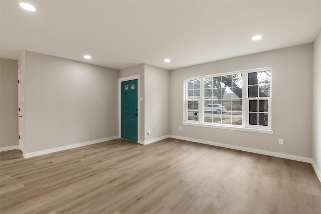 unfurnished room featuring recessed lighting, light wood-style flooring, and baseboards