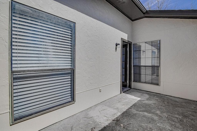 property entrance with a patio and stucco siding