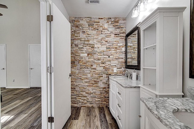 bathroom featuring visible vents, wood finished floors, and vanity