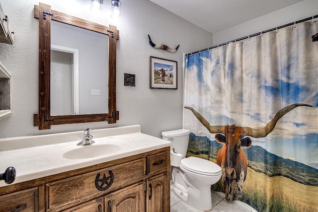 bathroom with a shower with curtain, a textured wall, toilet, vanity, and tile patterned flooring