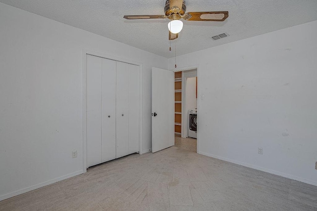 unfurnished bedroom with a textured ceiling, washer / clothes dryer, a closet, and visible vents