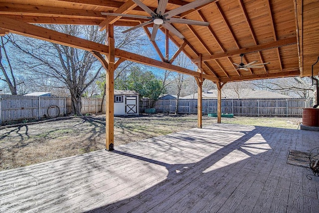 view of patio / terrace featuring a ceiling fan, a fenced backyard, an outdoor structure, and a storage unit