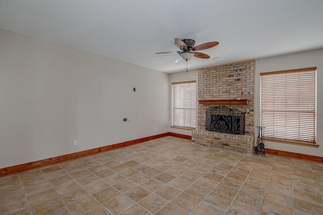 unfurnished living room with light tile patterned floors, ceiling fan, a fireplace, and baseboards