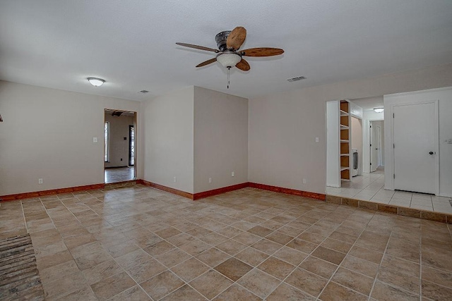 spare room with visible vents, baseboards, a ceiling fan, and light tile patterned flooring