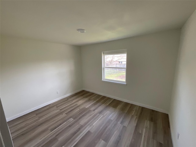 spare room with wood finished floors and baseboards