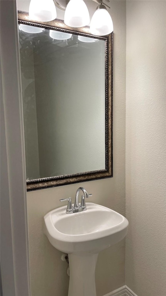 bathroom featuring a sink and a textured wall