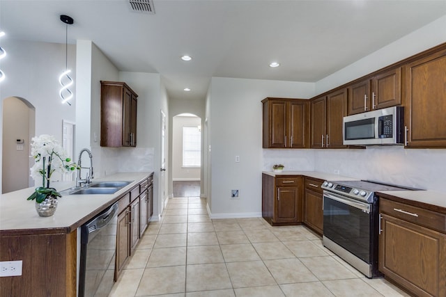 kitchen with visible vents, appliances with stainless steel finishes, light tile patterned flooring, arched walkways, and a sink