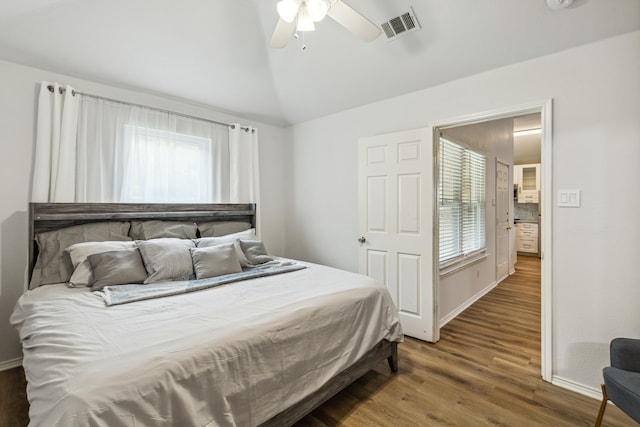 bedroom featuring lofted ceiling, wood finished floors, visible vents, and a ceiling fan