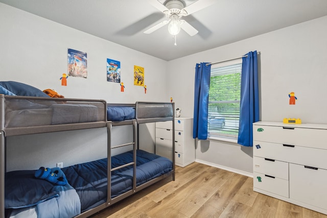 bedroom with light wood-type flooring, baseboards, and a ceiling fan